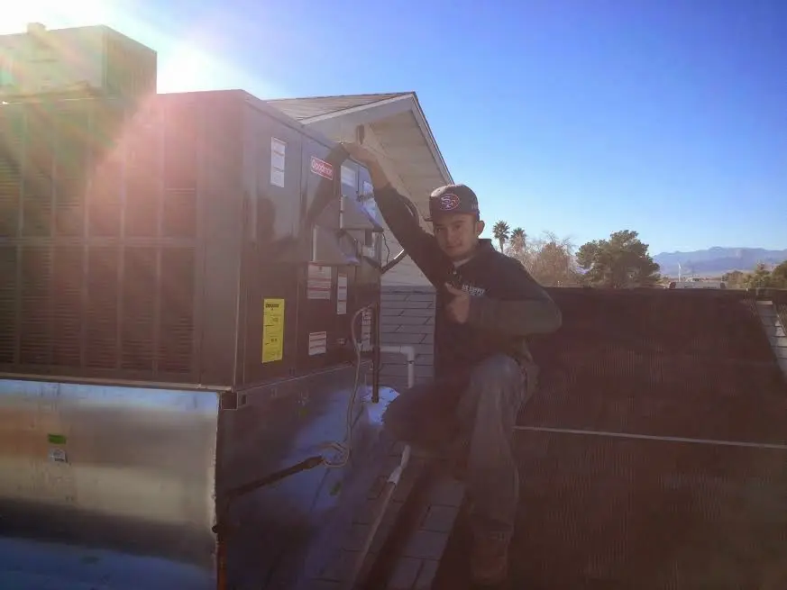 HVAC technician performing Air Duct Repair on a rooftop unit in Payson
